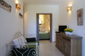 Cozy retreat with a single bed, flat-screen TV, and framed artwork.