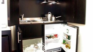 Une cuisine compacte dotée d’un réfrigérateur encastré et d’un évier.