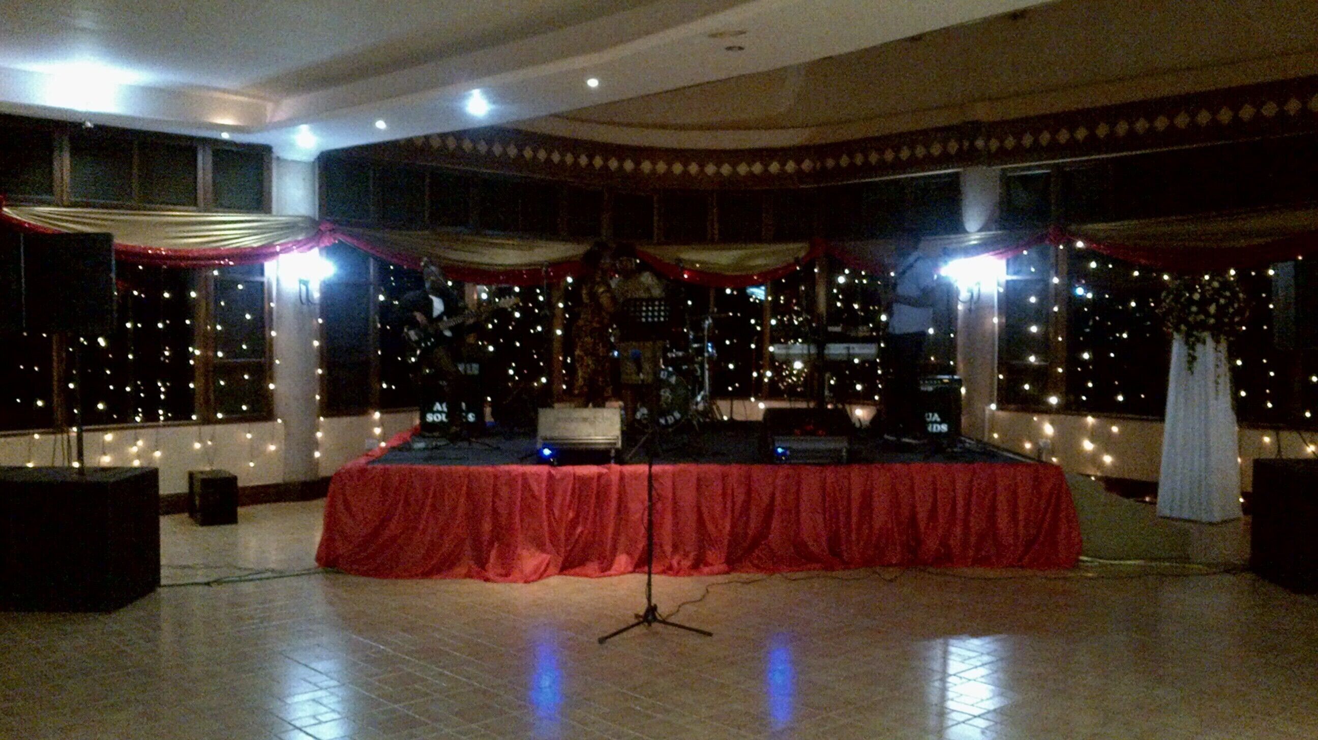 A stage with a red cloth, musical instruments, and a drum set.