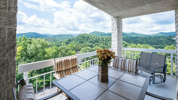 Ein Balkon mit Tisch, Stühlen und einem Blumenstrauß.