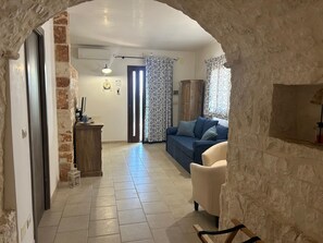 A living room with a sofa, a chair, a wooden cabinet, and a lamp. - New Fabulous Villa Fichi Private Pool, private terrace WIFi (Martina Franca)