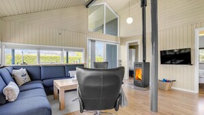 En moderne stue med sofa, stol, bord og pejs.