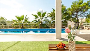 A poolside setting with a clear view of the pool, a wooden table with a bowl of fruit, and a vase with flowers. - Awesome apartment in Vir with WiFi (Vir)