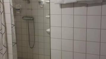 Baño con ducha, inodoro y toallero.