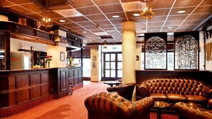A lobby with a bar area, leather seating, and decorative glass panels. - Chesterfield Hotel (Trondheim)