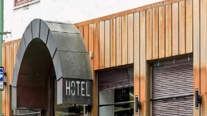 A hotel entrance with a wooden facade, a black awning, and a red door. - Chesterfield Hotel (Trondheim)