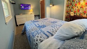 A bedroom with a bed, a dresser, a television, and a window. - Inground Pool, Arcade-Gameroom, 10 min to GR! (Wyoming)
