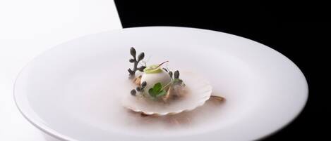 A white plate with a dessert on a reflective surface.