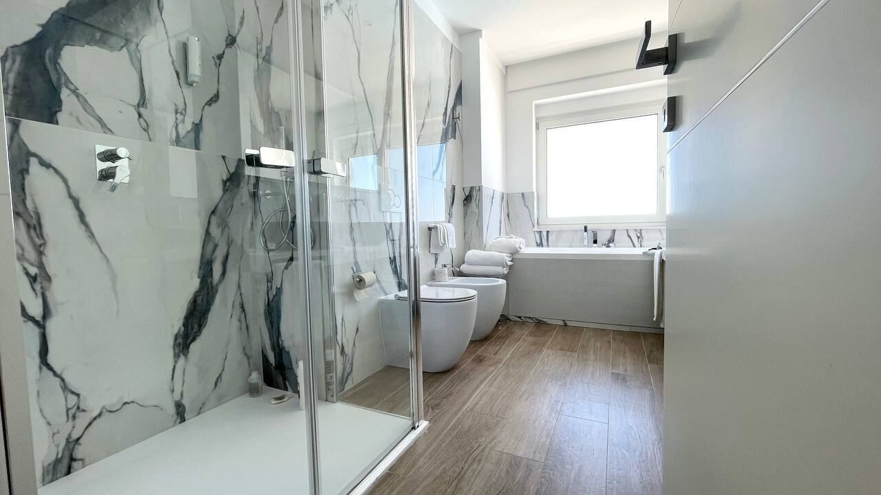 Un baño moderno con cabina de ducha de vidrio, inodoro y lavabo.