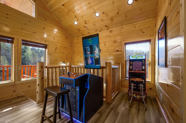 A wooden cabin interior with a bar area, a pool table, and a view of the outdoors. - Free Attractions | Indoor Heated Pool, Game Room, Fireplace, 2 Miles to Strip (Sevierville)