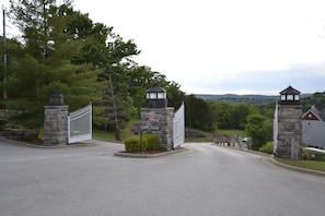 A gated entrance with stone pillars and a sign welcoming visitors.
