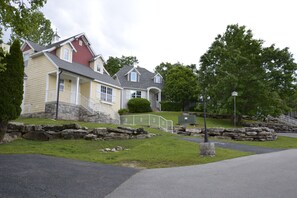 A residential area with houses, a stone retaining wall, and a paved driveway. - Fabulous 4BDR that sleeps 12 Cottage with Game Room in Stormy Point Village. (Branson)
