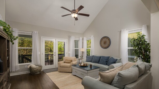 A spacious living room with a ceiling fan, a sofa, a chair, and a coffee table. - Lake House with Golf Cart (Tullahoma)