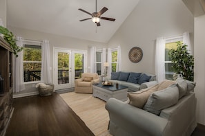 A spacious living room with a ceiling fan, a sofa, a chair, and a coffee table. - Lake House with Golf Cart (Tullahoma)