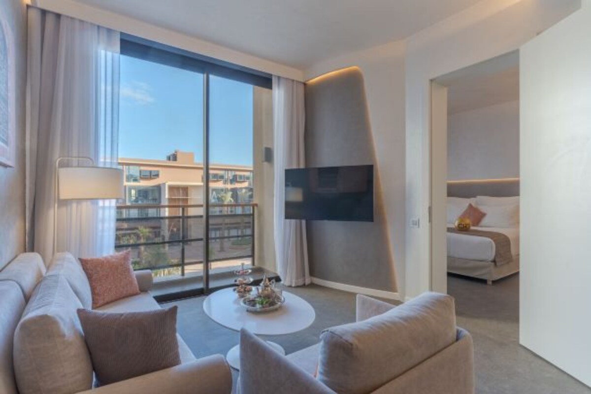 A hotel room with a sofa, coffee table, and a bed.