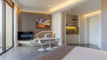 A modern living room with a sofa, two chairs, a TV, and a painting of a desert landscape.