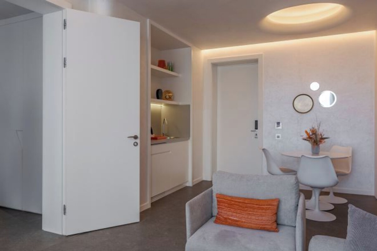 A modern interior with a dining area, a white door, and a kitchen.