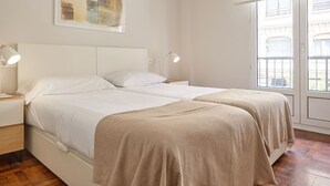 A bedroom with a bed, bedside lamps, a painting, and a window with a view. - Always Easy I Larroca (San Sebastián/Donostia)