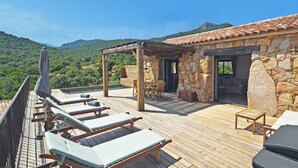 A wooden deck with lounge chairs and a table, overlooking a mountainous landscape. - BERGERIE STONE HOUSE - HEATED PRIVATE SWIMMING POOL A Stella (Conca)