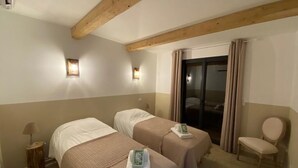 A hotel room with two beds, a chair, a lamp, and a sliding glass door. - BERGERIE STONE HOUSE - HEATED PRIVATE SWIMMING POOL A Stella (Conca)