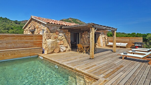 A wooden deck with a clear pool, stone walls, and a wooden pergola. - BERGERIE STONE HOUSE - HEATED PRIVATE SWIMMING POOL A Stella (Conca)