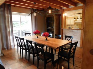 A dining area with a wooden table, black chairs, and two hanging pendant lights.