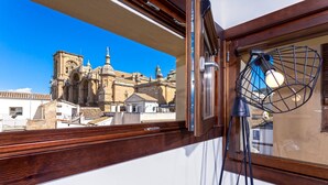 A view of a historic building through a window, with a tripod lamp inside. - Genteel Home Zacatin Penthouse 401 (Granada)