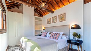 A bedroom with a large bed, a bedside table with a lamp, and a wardrobe. - Genteel Home Zacatin Penthouse 401 (Granada)