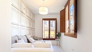 A bedroom with a large bed, a window with wooden shutters, and a hanging light fixture. - Genteel Home Zacatin 203 (Granada)