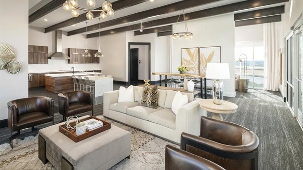 A modern hotel living room with a sofa, chairs, a coffee table, and a dining area with a table and chairs. - Family Friendly Beach Theme with Hot Tub! (Draper)