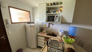 Une cuisine compacte équipée d’un réfrigérateur, d’un four à micro-ondes et d’un évier.