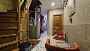 A narrow hallway with a wooden staircase on the left, a chair in the center, and a door labeled '3' on the right. - Taksim suite (Istanbul)