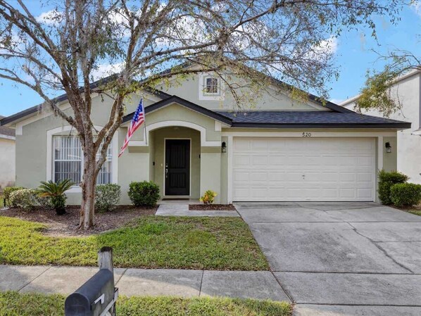 A single-story house with a garage, a front door, and a small front yard.