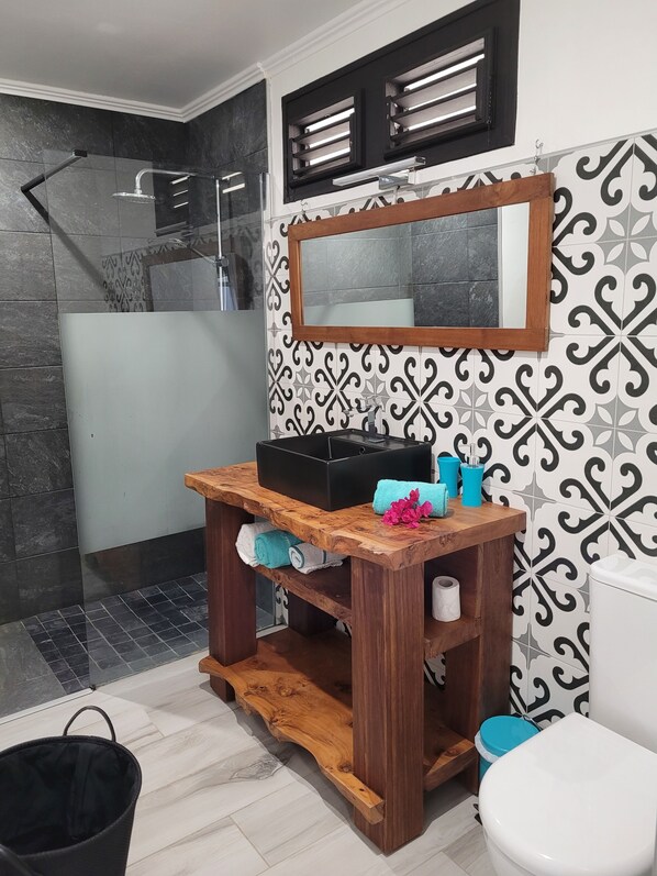 A bathroom with a shower, a vanity with a mirror, and a toilet. - NEW - 5mn from the 1st beaches, Caribbean sea view, quiet and central, wifi (Sainte-Luce)