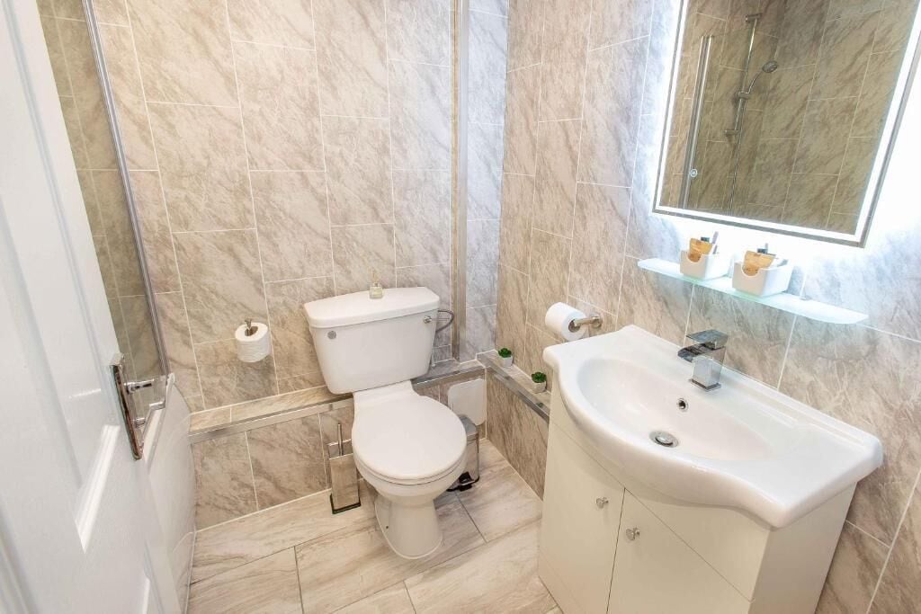 Un bagno con il water, un lavandino e uno specchio.