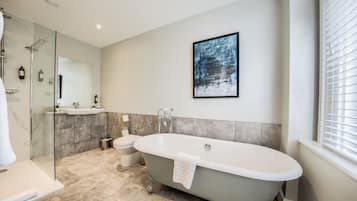 A modern bathroom with a freestanding bathtub, a glass-enclosed shower, a toilet, and a sink.