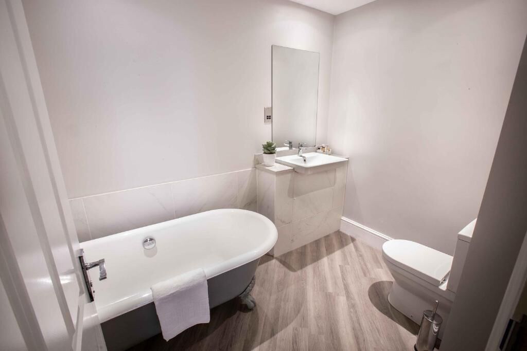 A modern bathroom with a freestanding bathtub, a sink, and a toilet.