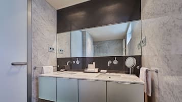 Een moderne badkamer met een grote spiegel, twee wasbakken en een handdoekrek.