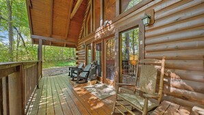 A wooden cabin with a porch, large windows, and outdoor seating. - ★Gray Fox Den★ • Secluded 3BR • Theater, Hot Tub, Arcade • Near Smokys/Downtown (Gatlinburg)