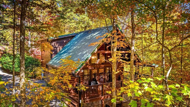A wooden cabin with a sloped roof, surrounded by autumn foliage. - ★Gray Fox Den★ • Secluded 3BR • Theater, Hot Tub, Arcade • Near Smokys/Downtown (Gatlinburg)