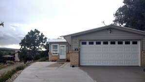 A residential garage with a white door and a brick wall. - Room with a View (Monticello)