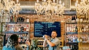 A bar with a brick wall, chandeliers, and a draft selection menu board. - Private 3Br Apt: King-2Queen -PetPally -LTR-STR (Bay Shore)