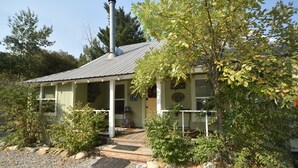 A single-story building with a porch, a chimney, and a gravel driveway. - ❤Riverfront Paradise - Butterfly Ranch on the River❤ (Dunsmuir)