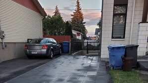 Ein gepflasterter Weg führt zu einer Garage, in der ein Auto geparkt ist.