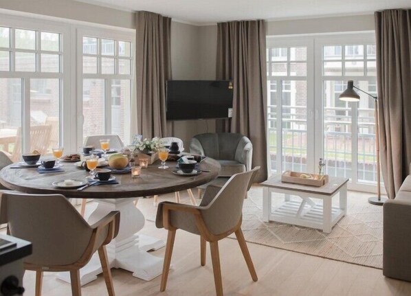 Un coin repas moderne avec une table ronde dressée pour le petit-déjeuner, entourée de chaises.