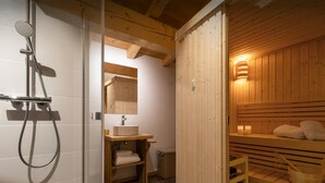 Un sauna avec un banc en bois, un lavabo et un miroir.
