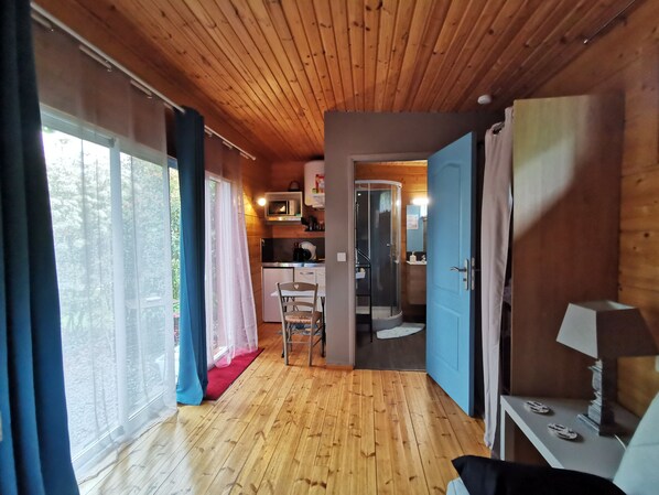 A wooden interior with a kitchen, a dining area, and a bathroom.