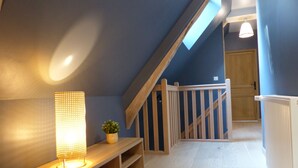 Eine Holzbank mit einer Lampe, einer kleinen Pflanze und einer Treppe mit Holzgeländer.