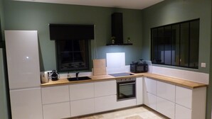 Eine moderne Küche mit weißen Schränken, einer schwarzen Mikrowelle und einem eingebauten Backofen.