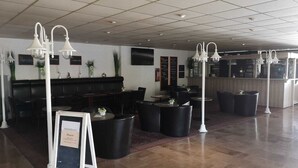 A spacious lobby with a reception desk, seating area, and a bar.